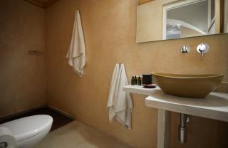 A bathroom in a cellar accommodation in oia santorini featuring a sink toilet and towel rack hu12597493530725887620.jpg