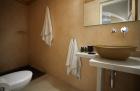 A bathroom in a cellar accommodation in oia santorini featuring a sink toilet and towel rack hu 3bc13a762f347998.jpg