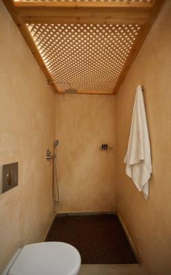 A bathroom in a cellar accommodation in oia santorini featuring a toilet and a shower hu2911985217864811281.jpg