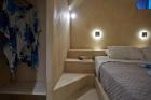 A blue and white floral print bed in a charming cellar accommodation in oia santorini hu 6193fc9ed9d47fa7.jpg