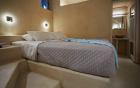 A cozy bed with a blue blanket in a charming cellar accommodation in oia santorini hu 1e68c4e154f819ba.jpg