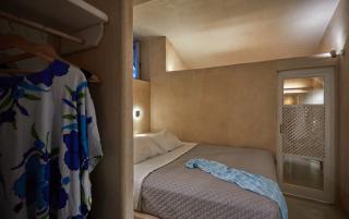 A cozy bedroom in a cellar in oia santorini featuring a bed and a closet for comfortable accommodation hu fd040c9a69631e31.jpg