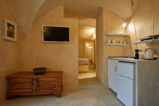 A cozy kitchen in a santorini cellar featuring a sink and a small table perfect for intimate meals hu 4f82b37f65c4b78d.jpg