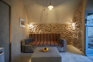 A cozy living room in a santorini cellar featuring a comfortable couch and a stylish table hu16104453363222709491.jpg