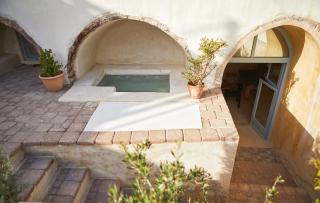 A cozy patio featuring a hot tub set in a transformed cellar in oia santorini offering a serene retreat hu e9102c7569a1d154.jpg