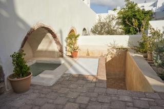 A serene courtyard featuring a small pool surrounded by a decorative wall creating a tranquil outdoor space hu 265c4a04738f9538.jpg