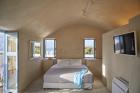 A serene bedroom featuring a bed and a window that offers a stunning view of the ocean hu bdc1c340a5ac3ccf.jpg