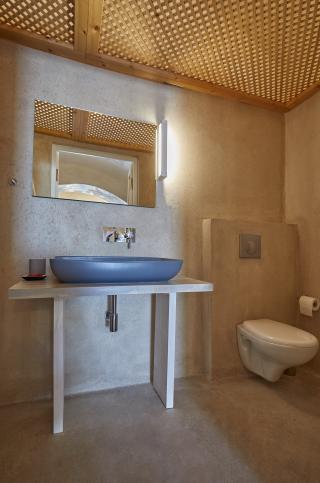 A bathroom featuring a sink and toilet part of a cellar accommodation in oia santorini with a private hot tub and veranda hu17247298425922371086.jpg