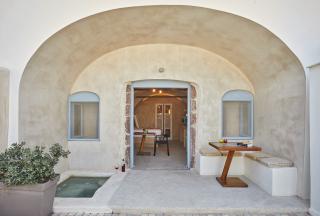 A charming doorway with arches leads to a cozy table showcasing a private hot tub and veranda in oia santorini hu4369610040807327313.jpg