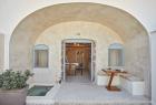 A charming doorway with arches leads to a cozy table showcasing a private hot tub and veranda in oia santorini hu f07e69e480f9cd2d.jpg
