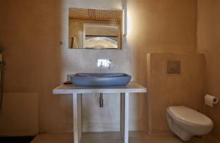 A cozy bathroom featuring a sink and toilet part of a cellar accommodation in oia santorini with a private hot tub hu13578935588667074301.jpg