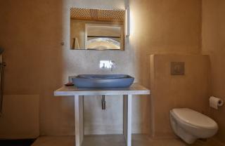 A cozy bathroom featuring a sink and toilet part of a cellar accommodation in oia santorini with a private hot tub hu 3dd9d1ac1c591982.jpg