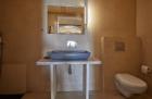 A cozy bathroom featuring a sink and toilet part of a cellar accommodation in oia santorini with a private hot tub hu 3dd9d1ac1c591982.jpg