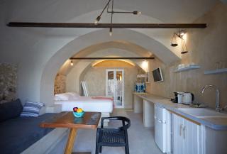 A cozy kitchen featuring a table and sink set in a charming oia cellar with a private hot tub and veranda hu ae0125969587ffff.jpg