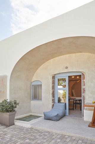 A cozy patio in oia santorini featuring a blue chair and table with a private hot tub and courtyard hu e2cc21596f10d4bd.jpg