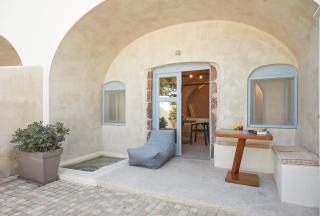 A cozy patio in oia santorini featuring a table and chairs with a private hot tub and courtyard for relaxation hu8040873324693406628.jpg