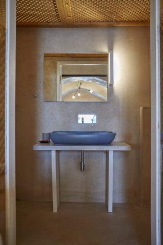 A stylish bathroom featuring a sink and mirror part of a cellar accommodation in oia santorini with a private hot tub hu3752807066660470730.jpg