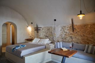 A cozy bedroom in oia santorini featuring a bed couch private hot tub and a charming veranda with a courtyard hu16615701088681760088.jpg