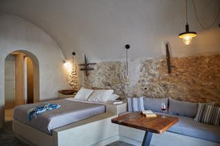A cozy bedroom in oia santorini featuring a bed couch private hot tub and a charming veranda with a courtyard hu e95e12db86859d06.jpg