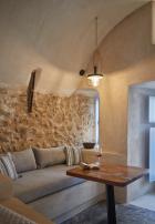 A cozy living room featuring a couch and table part of a cellar accommodation in oia santorini with a private hot tub hu 120eddf30bdbd16b.jpg